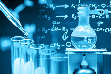 Dropping liquid to test tube with boiling chemical in round bottom flask, laboratory concept